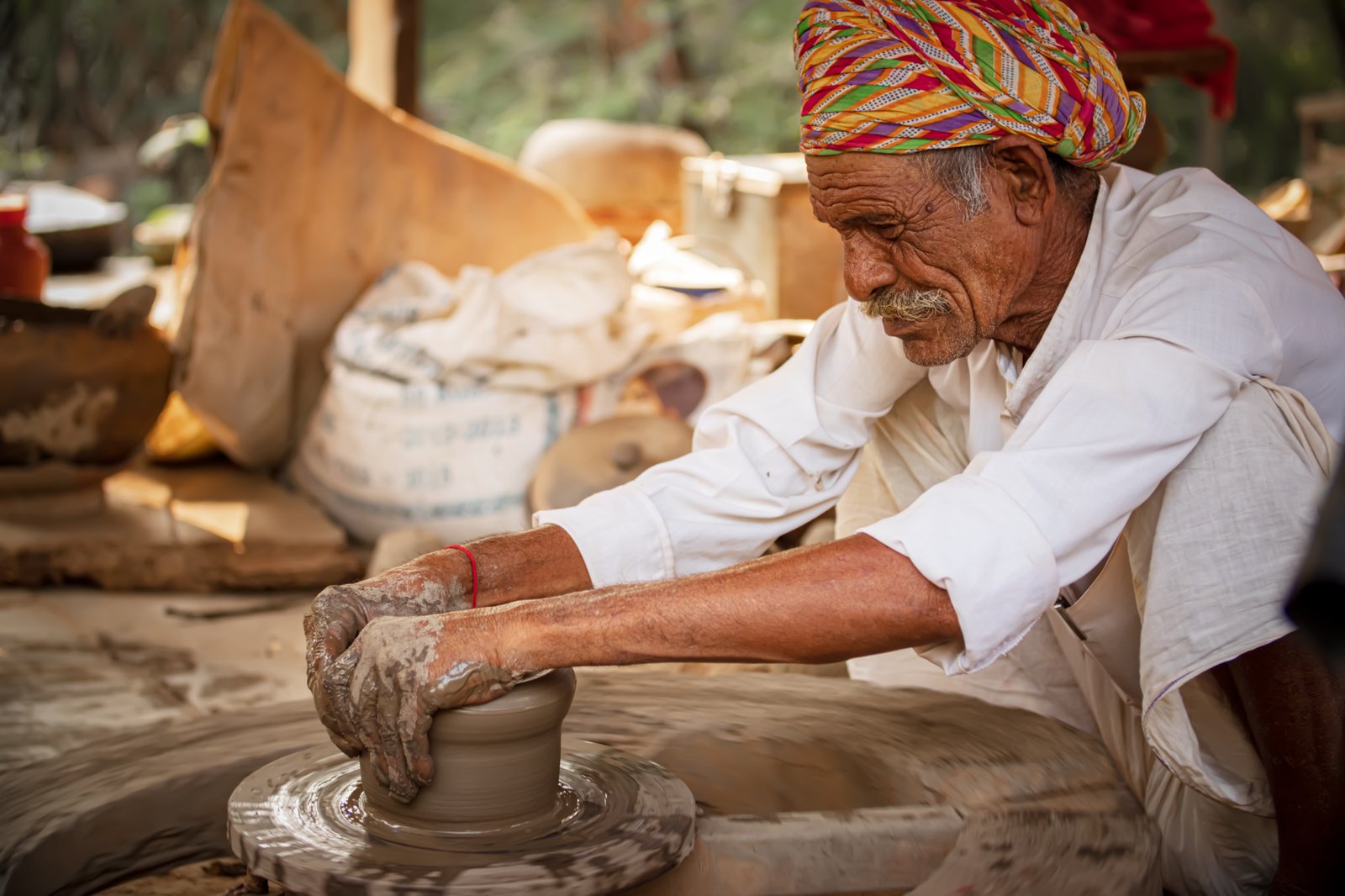 Artisan shaping clay on a pottery wheel